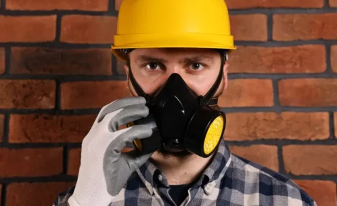 Worker wearing full PPE including helmet gloves and goggles